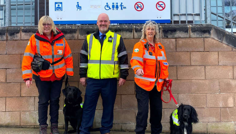 WightSAR Trainee Search Dog handler Catherine Fitton with Ginny, Wightlink Island Port Operations Manager Martin Gulliver and Trainee Search Dog handler Jasmine Light with Malli.